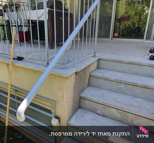 מעקה מתכת לבן על מדרגות חיצוניות